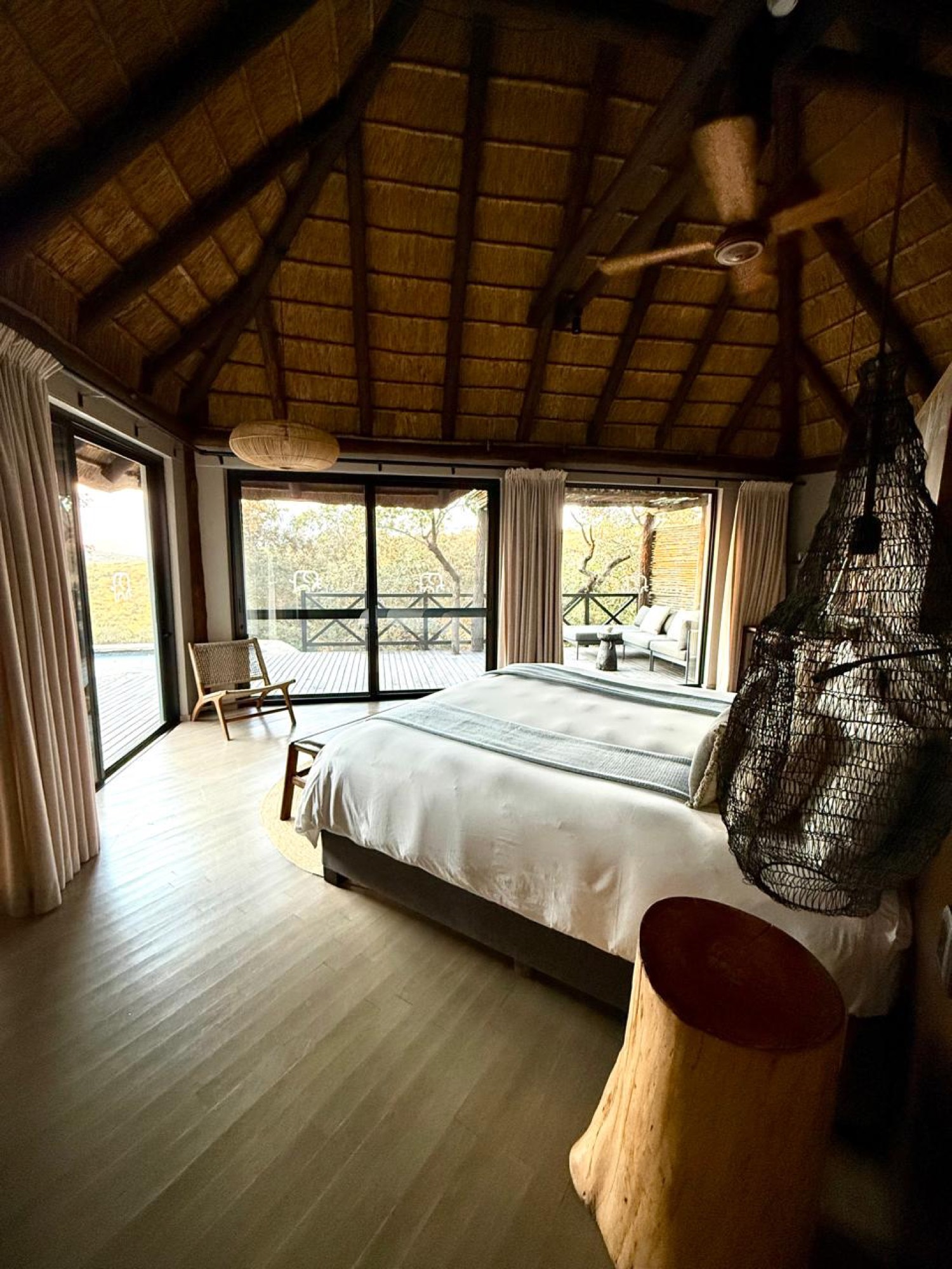 A warm, thatched safari lodge suite open to the bush